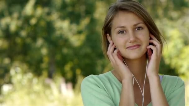 Jonge vrouw die naar muziek luistert via een hoofdtelefoon — Stockvideo