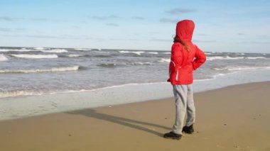 Küçük kız shore Baltık Denizi boyunca yürür