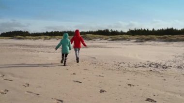 İki kız kardeş Shore Baltık Denizi boyunca yürüyüş