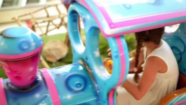 Két gyönyörű kislány lovagolni kis vonat játék — Stock videók