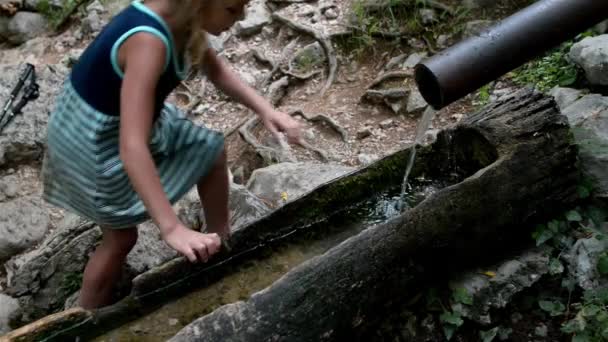 Niña está bebiendo agua de la primavera — Vídeo de stock