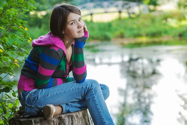 Girl sits on stub — Stock Photo, Image