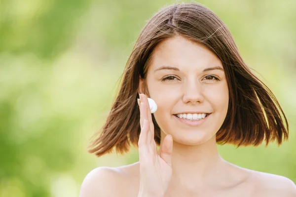 Portrait de jeune femme séduisante mettant de la crème sur son visage — Photo