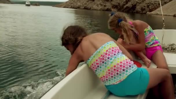 Две маленькие девочки плывут на лодке по Адриатическому морю — стоковое видео