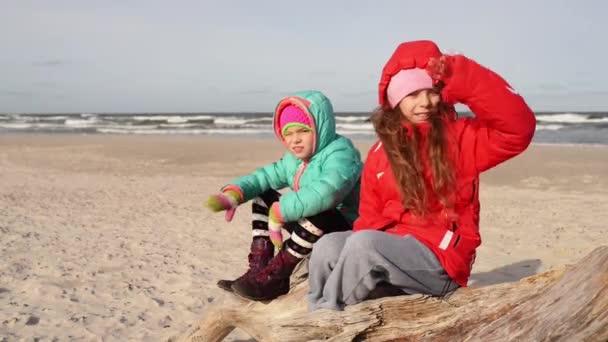 Petites belles filles est assis sur la mer — Video