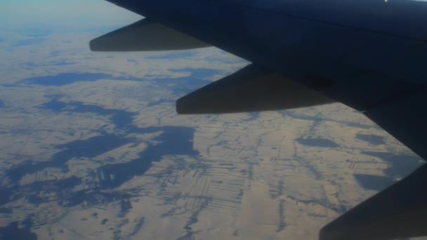 Avión vuela sobre campos cubiertos de nieve — Vídeo de stock