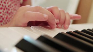 Kırmızı elbiseli küçük kız piyano çalıyor