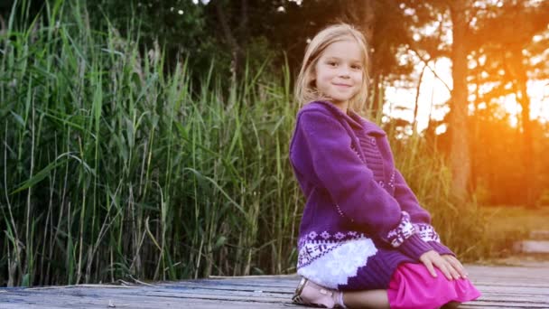 Malá holčička, která seděla na říční molu — Stock video