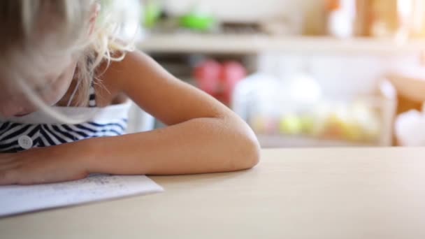 Niña escribiendo con bolígrafo en cuaderno — Vídeo de stock