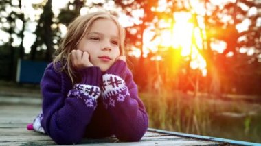 Küçük kız nehir iskelede yatıyor