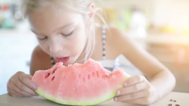 Beautiful blonde small girl eating watermelon — Stock Video