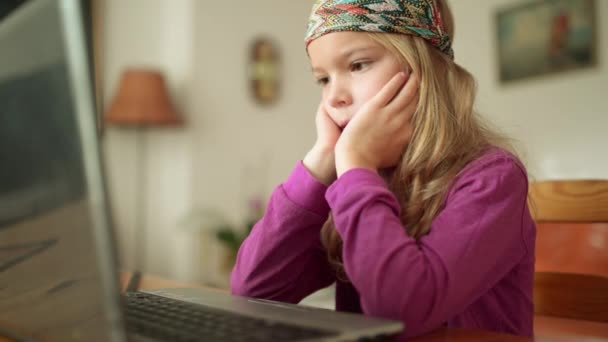 Little beautiful blonde girl working on a laptop on the background of a beautiful interior. — Stock Video