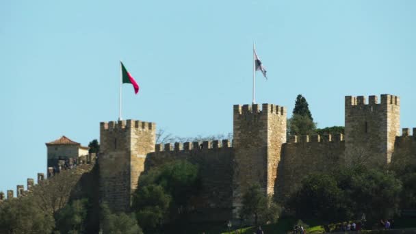 Sao Jorge-kastély a mór kastély, dombtetőn elhelyezkedő parancsoló a történelmi központjában, a portugál város a lisszaboni és a Tejo-folyóra. — Stock videók