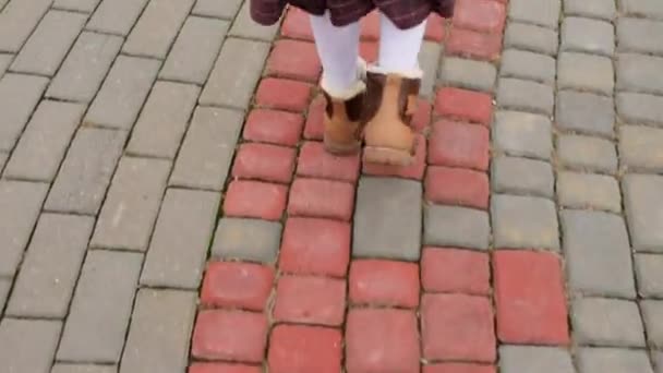 Маленькая красивая девочка идет по мощеной тротуаре в старой части европейского города . — стоковое видео