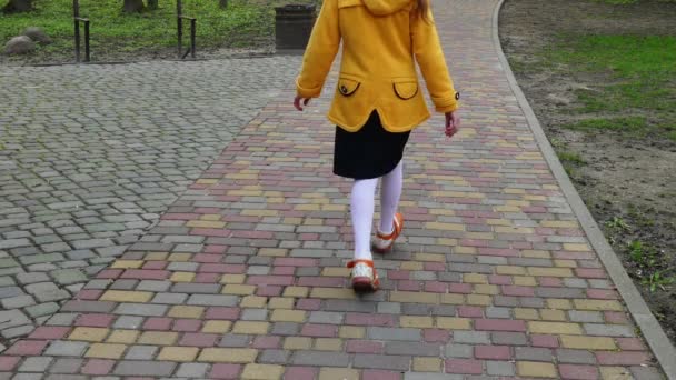 Lilla vackra flicka går på stenlagda trottoaren i den gamla delen av den europeiska staden. — Stockvideo