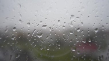Yağmur damlaları pencere camı üzerinde kentsel peyzaj arka plan üzerinde kayma..