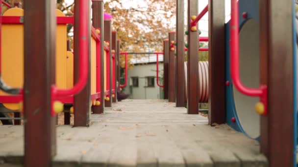 Bambina bella passeggiate sul parco giochi nel parco della città di autunno . — Video Stock