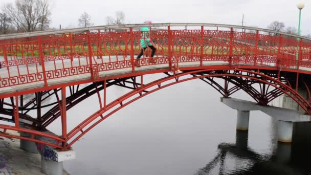 İki güzel kızın sonbahar Şehir Parkı gölette köprüden yürü. — Stok video