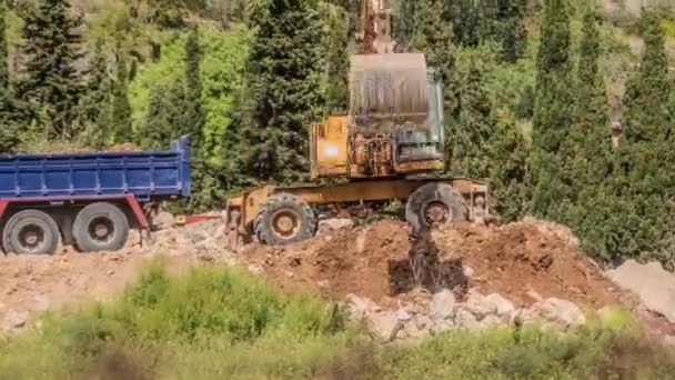 SOLLER, MALLORKA - 25 ABRIL 2016: Una gran excavadora amarilla rastrilla el suelo en las estribaciones del norte de Mallorca . — Vídeos de Stock