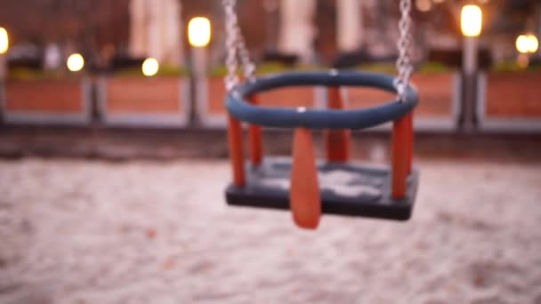 Kinderen swing voor de kinderen op de speelplaats in een Europese stad. — Stockvideo