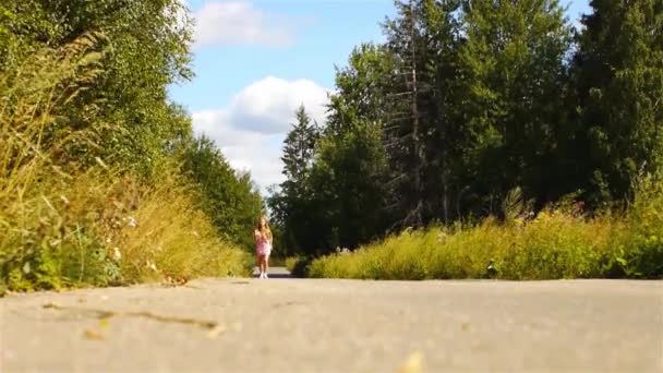 Hermosa joven corriendo en la carretera en el verde parque de verano . — Vídeos de Stock