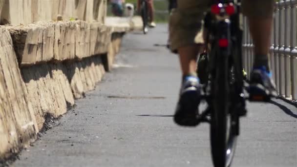 Radfahrer fährt auf rotem Radweg neben Gehweg. — Stockvideo