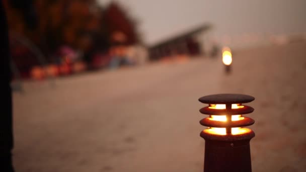 Lighted lantern on the background of people walking in evening autumn park. — Stock Video