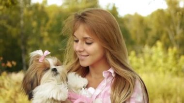Oldukça genç gülümseyen kadın tutarak küçük kabarık köpek, yaz yeşil park çerçevede portresi