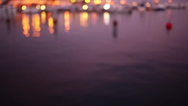 Iluminación nocturna en la orilla del mar con reflejo en el agua . — Vídeos de Stock