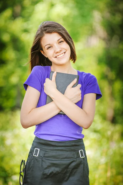 Porträt einer lachenden jungen Frau, die Buch liest — Stockfoto