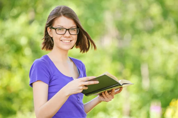 Porträtt av ung skrattande kvinna läser en bok — Stockfoto