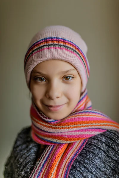 Pequena menina sorridente bonita em boné e cachecol — Fotografia de Stock