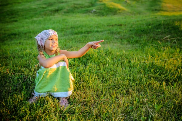 Çimlerde oturan küçük güzel kız — Stok fotoğraf