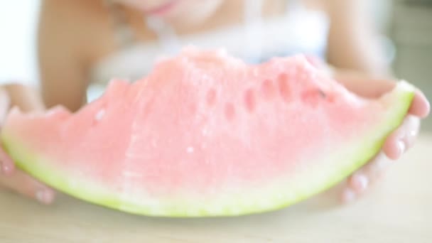 Linda menina loira comendo melancia no fundo da cozinha brilhante . — Vídeo de Stock