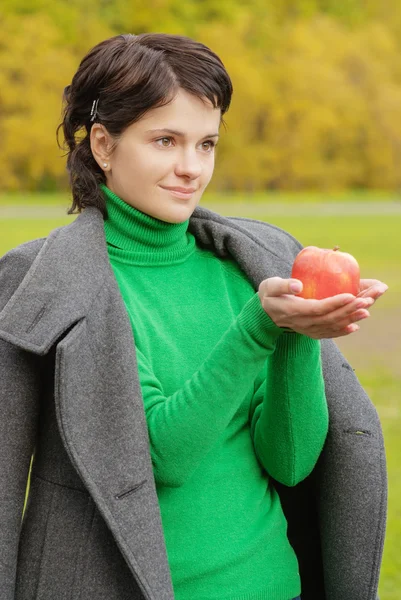 かわいい女性刺され熟したリンゴの笑みを浮かべてください。 — ストック写真