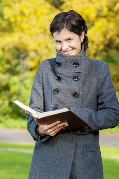 Kız ceket kitap okur — Stok fotoğraf