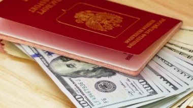 Rusya Federasyonu'nun kırmızı kapaklı yabancı pasaportları ve ABD doları.