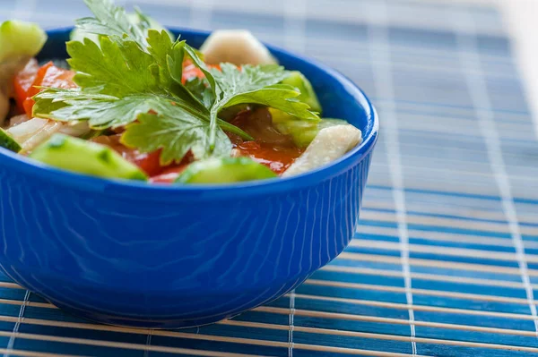 青竹のテーブルクロスに青いボウルにキュウリ トマト パセリのサラダ — ストック写真
