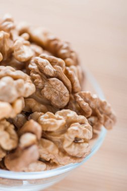 Bambu masa örtüsünün üzerinde kabuklu ceviz kasesi..