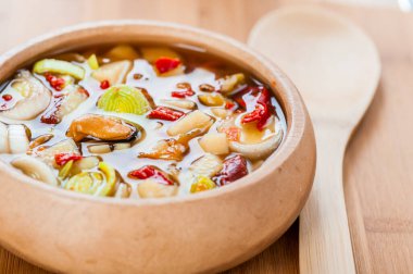 Geleneksel Tayland Tom Yam çorbası ve ahşap tabakta deniz mahsulleri..