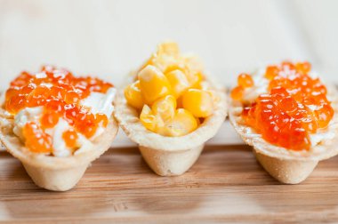 Kırmızı havyarlı turta ve ahşap masada mısır..