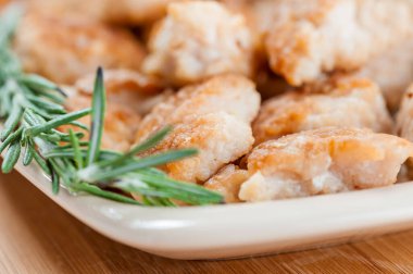 Ahşap masada biberiyeli kızarmış tavuk parçaları..