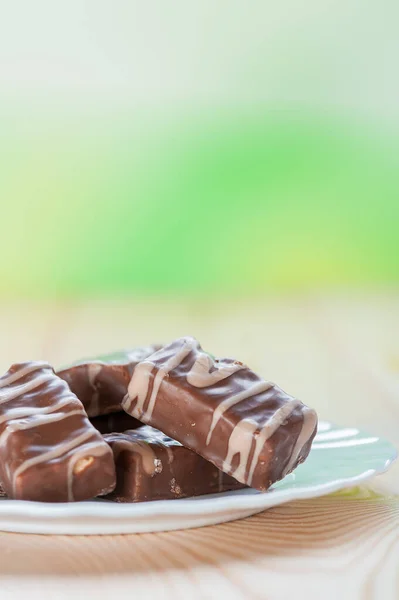 Deliziose Caramelle Cioccolato Trovano Piatto Bianco Tavolo Legno Uno Sfondo — Foto Stock