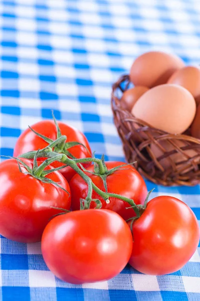 Kırmızı Domatesler Bir Dalda Sepette Yumurtalar Mavi Masa Örtüsünde — Stok fotoğraf