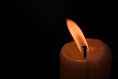 Siyah arkaplanda mum yakılıyor.
