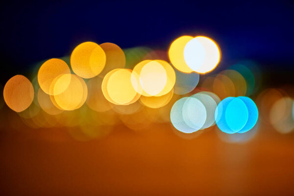 Defocused Christmas and new year lights background. Blurred bokeh with yellow and blue color lights.