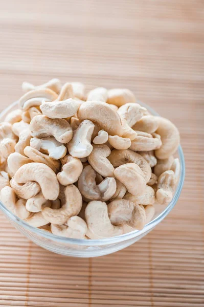 Glasschale Mit Geschälten Cashewnüssen Auf Einem Bambus Tischtuch — Stockfoto