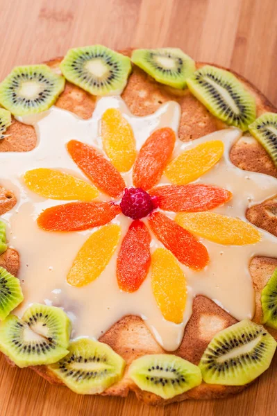 木の板にキウイとパイナップルのスライスとクリームとケーキ — ストック写真