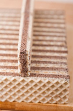 Uzun dikdörtgen çikolatalı gofretler tahta bir kesme tahtasının üzerinde yatıyor..