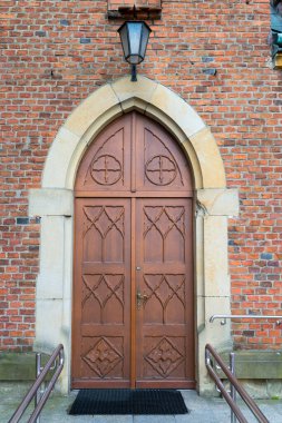 Eski bir İtalyan evinde lambalı, devasa ahşap bir kapı..